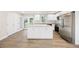 Modern kitchen features an island, white cabinets, stainless appliances, and new hardwood floors at 2805 Long Way, Decatur, GA 30032