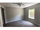 Cozy bedroom with neutral walls, new carpeting, ample natural light, and ceiling fan at 50 Ivy St, Porterdale, GA 30014