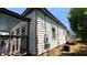 An eye-level exterior shot showcasing the side of the house with light colored siding and brown trim at 50 Ivy St, Porterdale, GA 30014