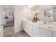 Well-lit bathroom featuring double sinks with stone countertop, stylish decor, and an open view to the main bedroom at 115 Maplewood Ln, Conyers, GA 30094