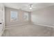 Spacious bedroom with plush carpeting, two bright windows, and a ceiling fan at 1215 Comet View Se Trl, Smyrna, GA 30082