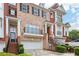 Brick townhome featuring an attached garage, upper balcony, and manicured shrubbery at 1215 Comet View Se Trl, Smyrna, GA 30082