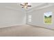 Spacious bedroom featuring a tray ceiling, a fan, and two windows at 208 Sharon Ln, Loganville, GA 30052