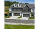A row of modern townhomes boasts gray and white exteriors with individual driveways at 208 Sharon Ln, Loganville, GA 30052