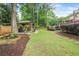 This backyard features a gazebo, a grassy area, mature trees, and landscaping at 435 Trammell Dr, Alpharetta, GA 30009
