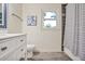 This bathroom features a toilet, a vanity, gray flooring, and a window at 435 Trammell Dr, Alpharetta, GA 30009