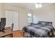 This bedroom features a ceiling fan, a window, a bed with blanket, a table, and a closet at 435 Trammell Dr, Alpharetta, GA 30009