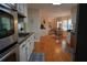Open kitchen with white cabinets, hardwood floors, stainless steel appliances, and breakfast area at 435 Trammell Dr, Alpharetta, GA 30009
