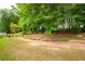 Backyard landscaping with brick trim, a large lawn, and lush surrounding trees at 55 Cross Pointe Ct, Hiram, GA 30141