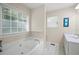 Bright bathroom featuring a soaking tub under a large window and a white vanity with a sink at 55 Cross Pointe Ct, Hiram, GA 30141