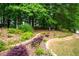 Landscaping with brick trim, red and green plants, and lush surrounding trees at 55 Cross Pointe Ct, Hiram, GA 30141