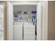 Laundry area with side-by-side washer and dryer, with storage shelves for supplies at 55 Cross Pointe Ct, Hiram, GA 30141
