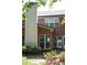 Backyard showing brick exterior, large windows, manicured bushes and blooming pink flowers at 601 Hexham Ct, Suwanee, GA 30024