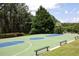 Outdoor basketball court is surrounded by tall trees and benches at 601 Hexham Ct, Suwanee, GA 30024