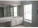 Bright bathroom featuring a vanity with drawers, sink, mirror, and glass shower with natural light at 601 Hexham Ct, Suwanee, GA 30024