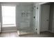 Bathroom featuring a walk-in shower with stone tile and a glass door at 601 Hexham Ct, Suwanee, GA 30024