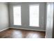 Neutral-colored bedroom featuring hardwood floors and natural light from two windows at 601 Hexham Ct, Suwanee, GA 30024