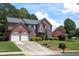 Charming two-story brick home with a well-manicured lawn, mature trees, and a two-car garage at 601 Hexham Ct, Suwanee, GA 30024