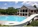 Community pool with a water slide and lounge chairs, next to a clubhouse at 601 Hexham Ct, Suwanee, GA 30024