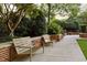 Peaceful outdoor seating area with benches, surrounded by lush greenery and brick walls, perfect for relaxation at 1820 Peachtree Nw St # 1110, Atlanta, GA 30309