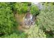 Aerial view of a home nestled among lush trees featuring a unique roof and outdoor pool at 1909 Moores Mill Nw Rd, Atlanta, GA 30318