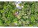 Aerial view of a home nestled in lush greenery, with a pool and mature trees providing privacy and shade at 1909 Moores Mill Nw Rd, Atlanta, GA 30318