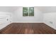 Finished attic space featuring hardwood floors, white walls, and a window looking out into the back yard at 1909 Moores Mill Nw Rd, Atlanta, GA 30318