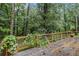 View of wooden deck with a wood and metal railing, surrounded by mature trees, for a peaceful outdoor space at 1909 Moores Mill Nw Rd, Atlanta, GA 30318