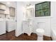 Bright bathroom featuring hardwood floors, a single vanity, modern fixtures, and a washer/dryer hookup at 1909 Moores Mill Nw Rd, Atlanta, GA 30318
