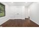 Bedroom with hardwood floors, white walls, large window and natural light from trees, plus access to hall at 1909 Moores Mill Nw Rd, Atlanta, GA 30318
