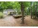 Charming home exterior with a front deck and storage shed, set amongst mature trees and landscaping at 1909 Moores Mill Nw Rd, Atlanta, GA 30318