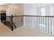 Hallway with carpet, wrought iron railing, and access to a laundry room at 3241 Alhambra Cir, Hampton, GA 30228
