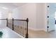 Carpeted hallway featuring a wood and wrought iron railing and white trim at 3241 Alhambra Cir, Hampton, GA 30228