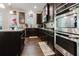 Well-appointed kitchen with dark wood cabinets, stainless steel appliances, granite countertops, and dark wood floors at 3241 Alhambra Cir, Hampton, GA 30228