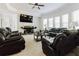 Spacious living room with neutral walls, plush carpet, a fireplace, and comfortable leather seating at 3241 Alhambra Cir, Hampton, GA 30228