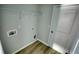 Clean laundry room with wood-look flooring, shelving, and utility connections at 967 Park Place St, Social Circle, GA 30025