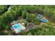 Aerial view of community pool, tennis courts, and surrounding wooded area in a serene setting at 1045 River Pt, Suwanee, GA 30024