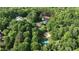 Lush, wooded aerial view of a property featuring tennis courts, pool, and clubhouse at 1045 River Pt, Suwanee, GA 30024