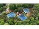Aerial view of three well-maintained community tennis courts nestled among mature trees at 1045 River Pt, Suwanee, GA 30024