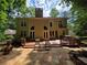Expansive backyard features a wooden deck, stone patio, and lush green surroundings at 1045 River Pt, Suwanee, GA 30024