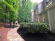 Stone pathway leads to a backyard area with an outdoor fireplace and lush landscaping at 1045 River Pt, Suwanee, GA 30024