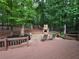 Large backyard with deck, stone fireplace, patio seating, and play set in the distance at 1045 River Pt, Suwanee, GA 30024