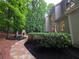 Lush backyard with stone pathway leading to a stone fireplace, deck, and landscaped area at 1045 River Pt, Suwanee, GA 30024
