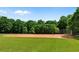 Ground view of baseball field surrounded by lush greenery and mature trees at 1045 River Pt, Suwanee, GA 30024