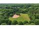 Aerial view of a baseball field surrounded by lush greenery and mature trees at 1045 River Pt, Suwanee, GA 30024