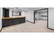 Basement bar area with dark wood countertop, tile flooring, and an adjacent carpeted living space at 1045 River Pt, Suwanee, GA 30024