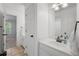 Bright white bathroom featuring a modern sink, tan tile flooring, and a view into the bedroom at 1045 River Pt, Suwanee, GA 30024