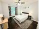 Comfortable bedroom features a queen-sized bed, ceiling fan, hardwood floors and ample natural light at 1045 River Pt, Suwanee, GA 30024