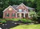 Charming brick home with a well-manicured lawn and lush landscaping at 1045 River Pt, Suwanee, GA 30024