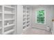 Well-lit hallway with built-in shelving and natural light from the window at 1045 River Pt, Suwanee, GA 30024